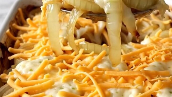 A top-down view of a rectangular baking dish filled with rows of sweet onion slices topped with melted cheese.