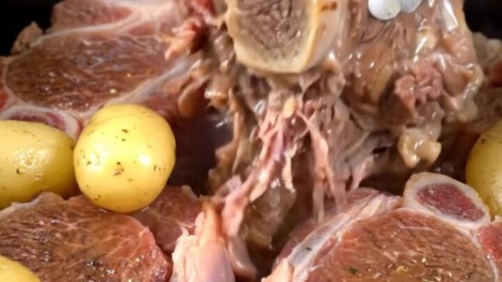 Tender beef shanks with baby gold potatoes served in a savory buttery herb broth in a rustic dish.