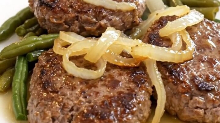 Four slow-cooked beef patties with green beans and halved baby potatoes in a slow cooker.