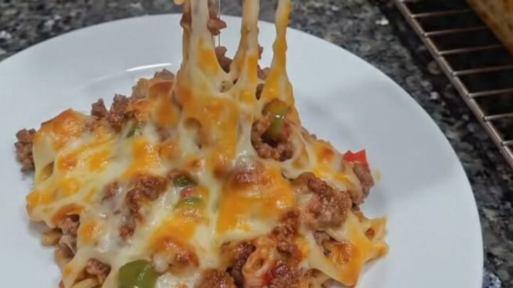 A close-up of a spatula lifting a portion of cheesy ground beef casserole