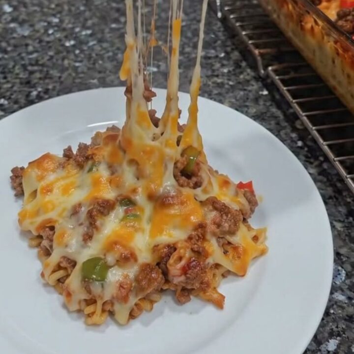 A close-up of a spatula lifting a portion of cheesy ground beef casserole