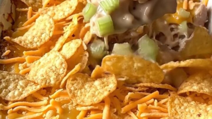 A golden-brown hot chicken salad casserole in a white ceramic dish.