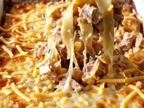A rectangular baker filled with a golden, cheesy baked noodle and ground turkey dish.