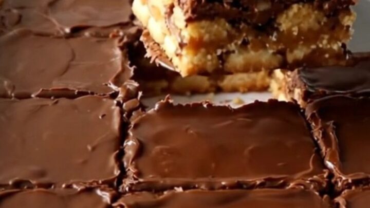A top-down view of Christmas saltine toffee bars in a white ceramic baking dish, showcasing a golden cracker base.