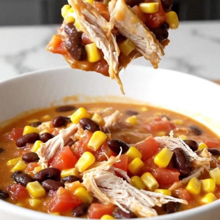 A bowl of creamy slow cooker chicken chili with shredded chicken, beans, and corn.