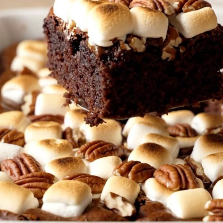A rectangular ceramic dish filled with freshly baked Mississippi Mud Brownies topped with toasted marshmallows and pecans.
