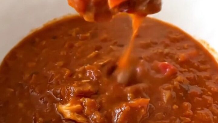 A steaming bowl of thick, beanless turkey chili centered on a table.
