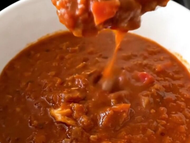 A steaming bowl of thick, beanless turkey chili centered on a table.