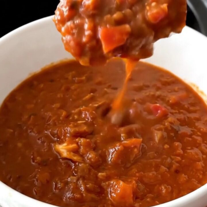 A steaming bowl of thick, beanless turkey chili centered on a table.