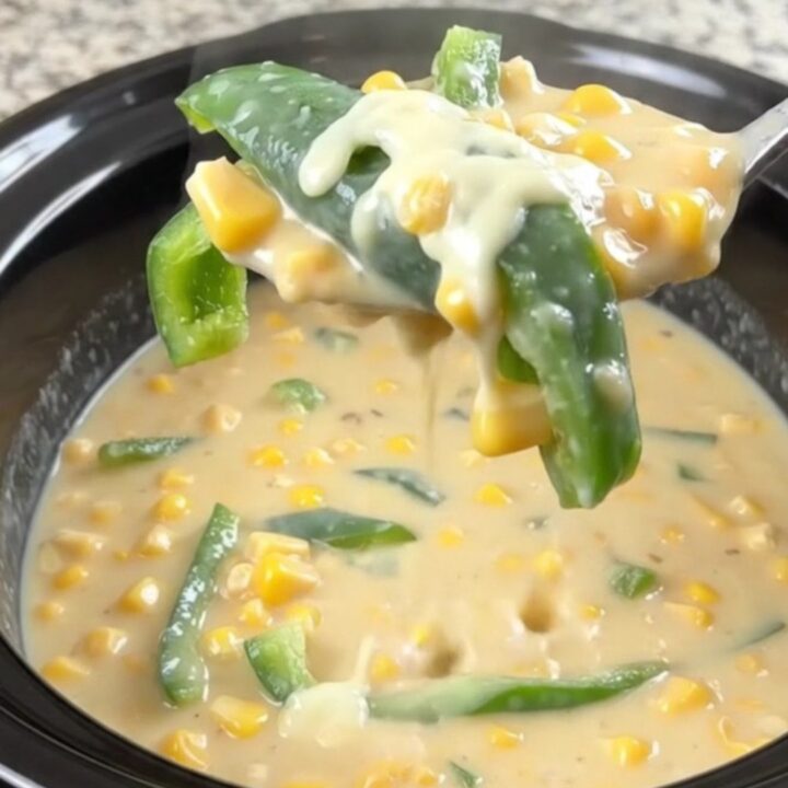 A bowl of creamy poblano chile relleno soup with visible poblano strips and corn kernels.