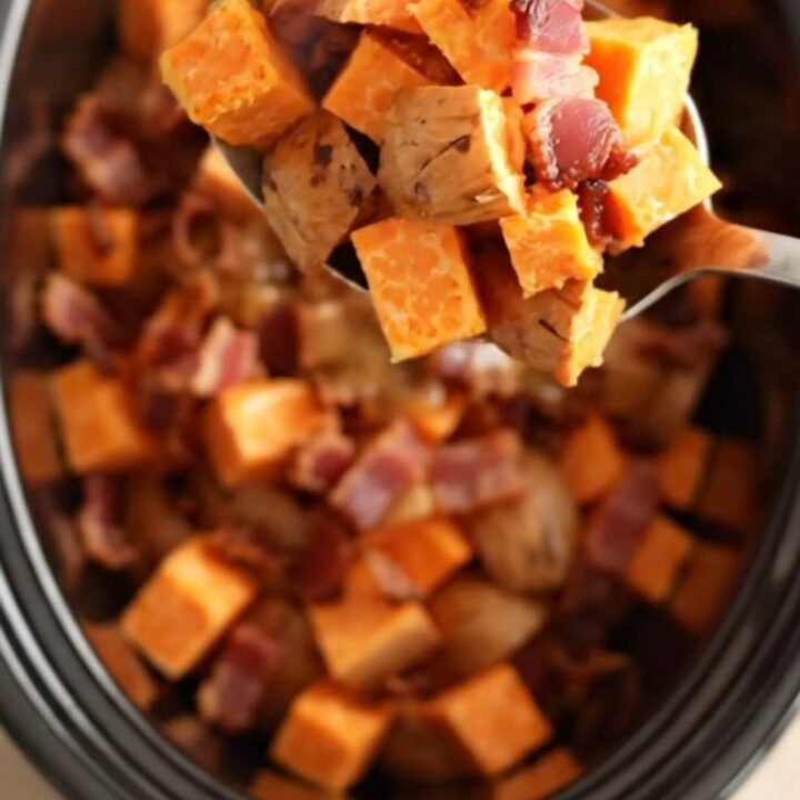 A close-up view of maple bacon sweet potatoes served in a rustic bowl, showing glossy glaze.