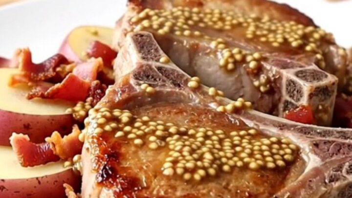 Slow cooker German pork chops with potatoes and bacon on a light butcher-block counter.