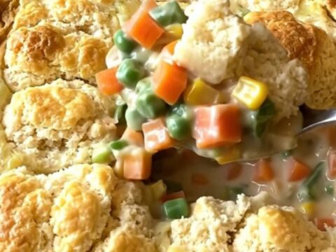 A large rectangular baking dish filled with a creamy vegetable mix topped with golden baked biscuit pieces.