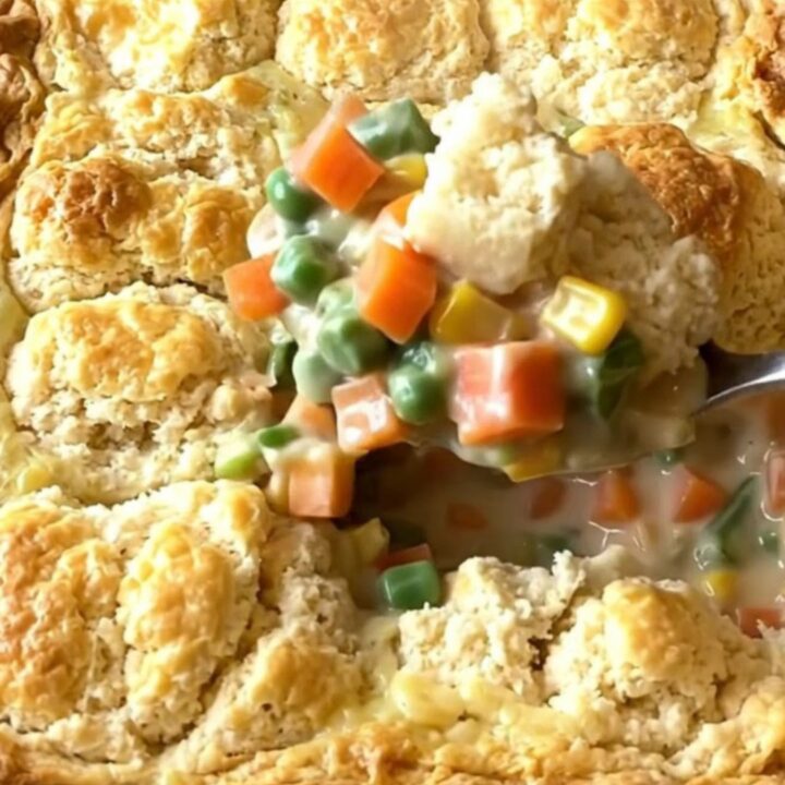 A large rectangular baking dish filled with a creamy vegetable mix topped with golden baked biscuit pieces.