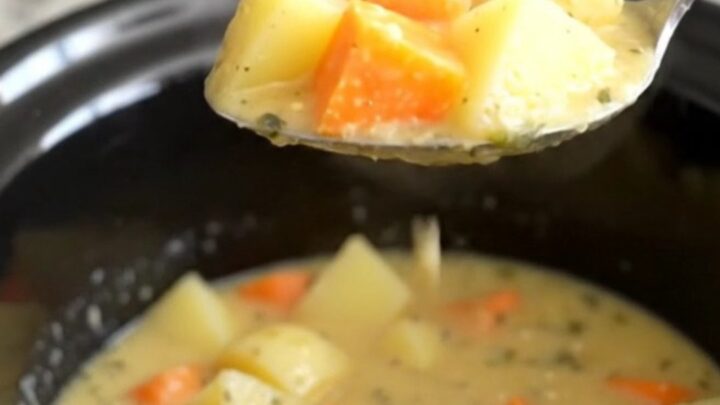 A close-up view of the creamy root vegetable chowder in a slow cooker insert.