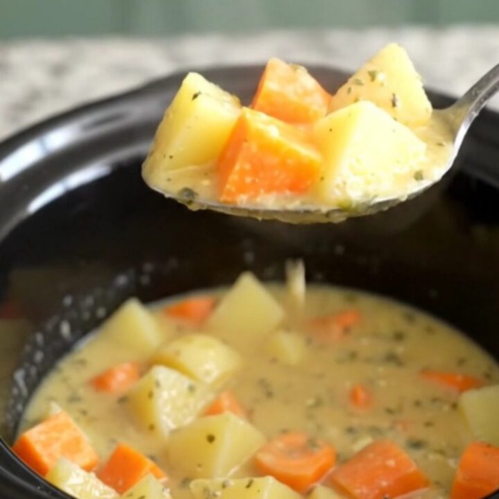 A close-up view of the creamy root vegetable chowder in a slow cooker insert.