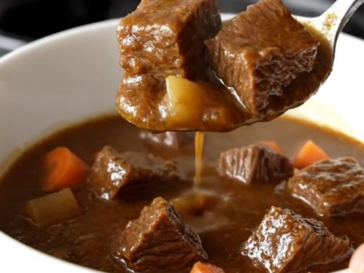 A close-up of a bowl of Jamaican-style beef and butter bean stew with visible chunks of tender beef and carrots.