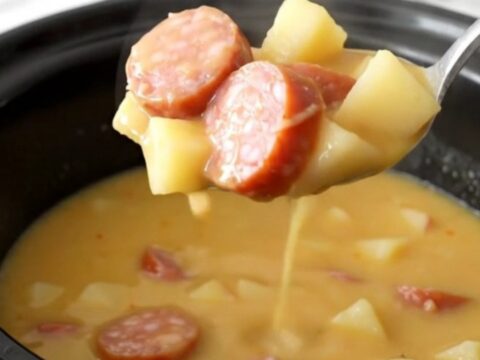 A bowl of creamy Crockpot Smoked Sausage Apple Cheddar Chowder with visible sausage coins and potato cubes.