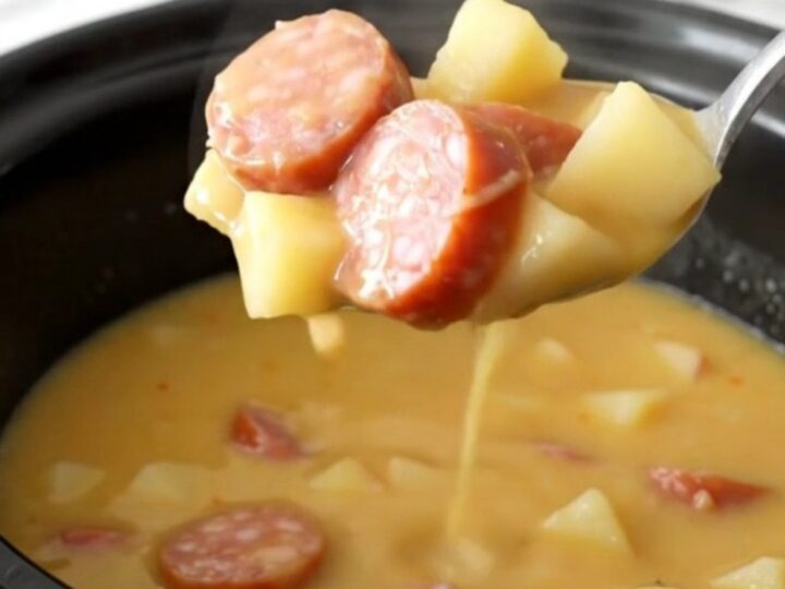 A bowl of creamy Crockpot Smoked Sausage Apple Cheddar Chowder with visible sausage coins and potato cubes.