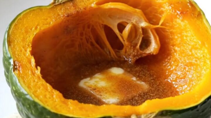 Two halves of acorn squash in a slow cooker topped with butter, brown sugar, and cinnamon.
