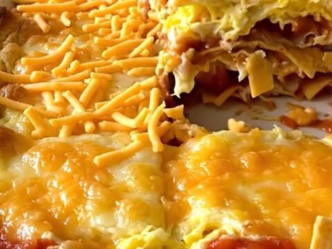A golden, puffed Tex-Mex migas egg bake in a white ceramic dish.