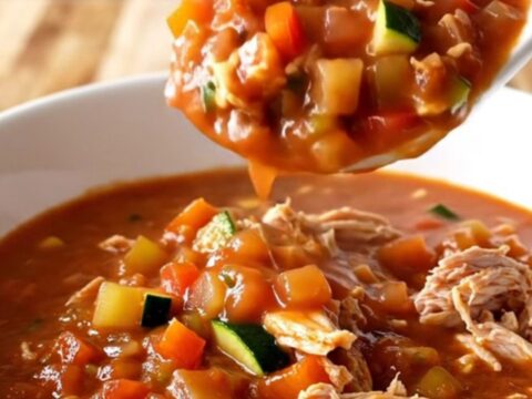 A white bowl filled with hearty ground turkey and vegetable chili with steam rising from the surface.