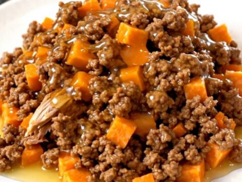 A slow cooker filled with cooked ground turkey and tender sweet potato cubes glazed in a shiny hot honey sauce.