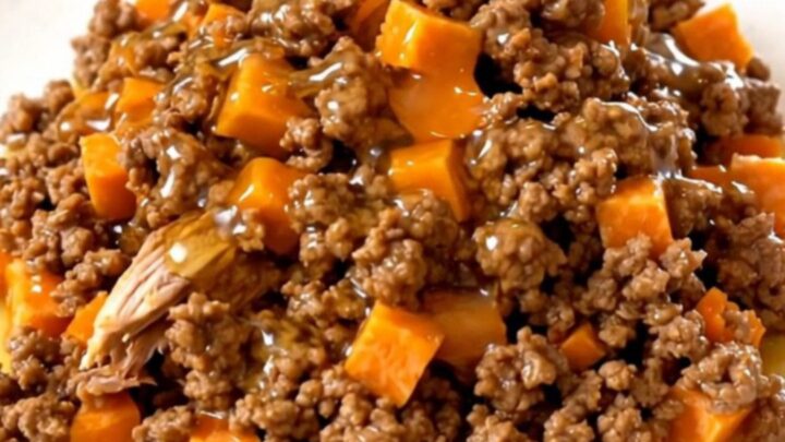 A slow cooker filled with cooked ground turkey and tender sweet potato cubes glazed in a shiny hot honey sauce.
