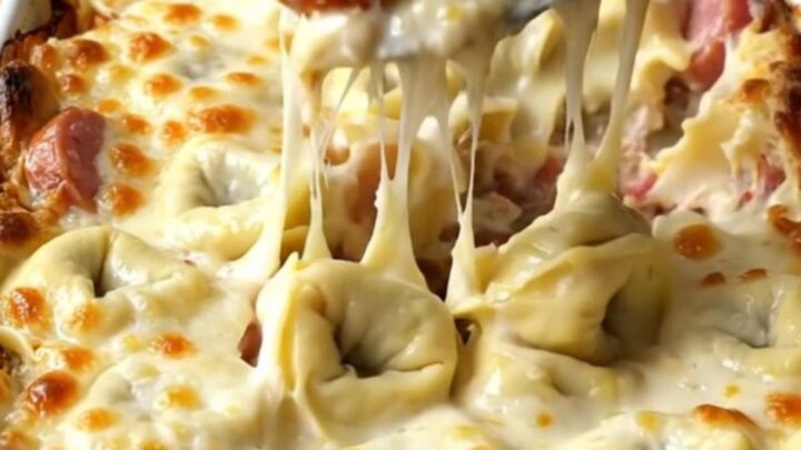 A top-down view of a rectangular baking dish filled with cheese tortellini, smoked sausage