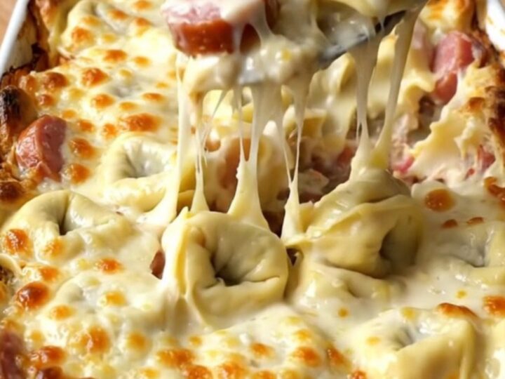 A top-down view of a rectangular baking dish filled with cheese tortellini, smoked sausage