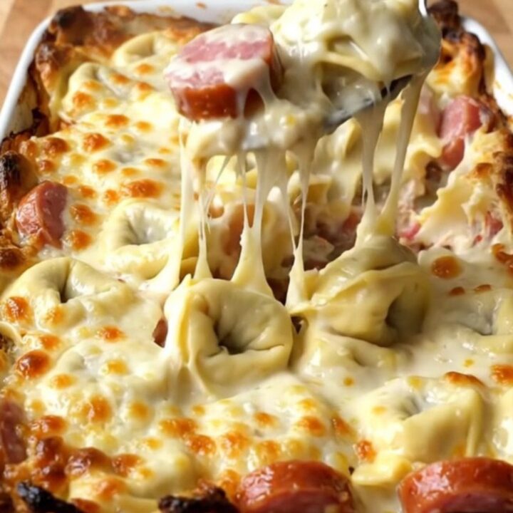 A top-down view of a rectangular baking dish filled with cheese tortellini, smoked sausage
