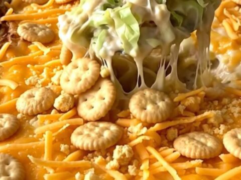 A top-down view of a rectangular baking dish filled with a creamy cabbage casserole topped with golden cracker crumbs.