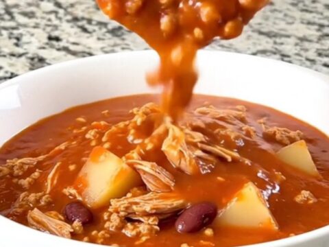 A rustic bowl of tomato-based shipwreck stew featuring ground turkey, beans, and potato cubes.