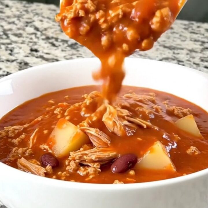 A rustic bowl of tomato-based shipwreck stew featuring ground turkey, beans, and potato cubes.