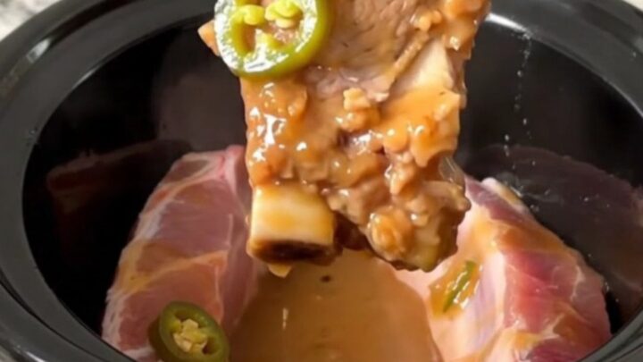 A close-up of tender, boneless country-style pork ribs glazed in a shiny, sweet and spicy sauce with jalapeno slices.
