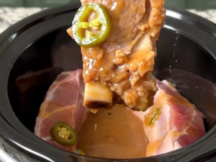 A close-up of tender, boneless country-style pork ribs glazed in a shiny, sweet and spicy sauce with jalapeno slices.
