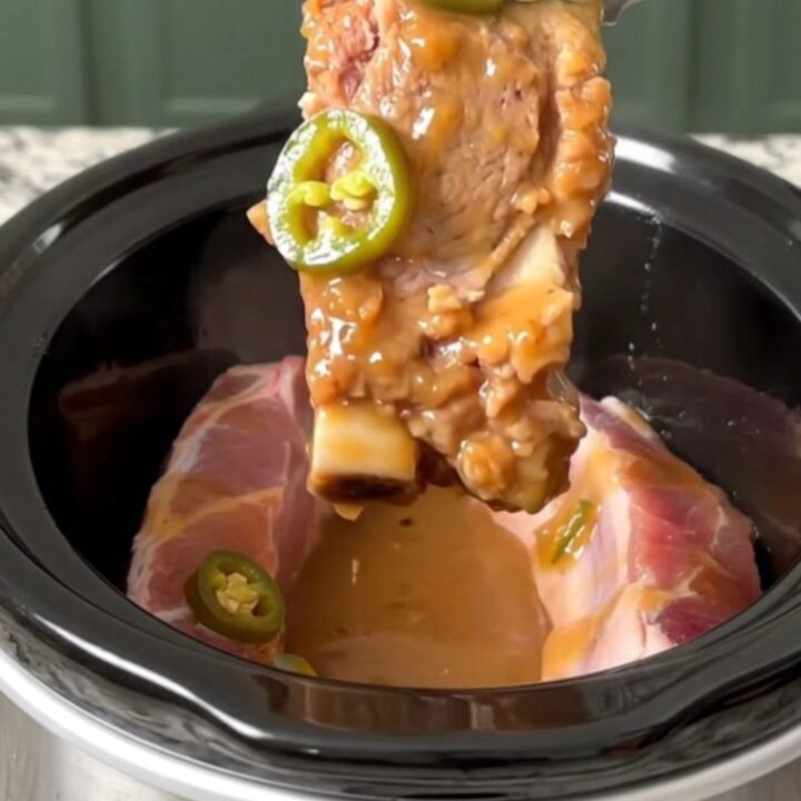 A close-up of tender, boneless country-style pork ribs glazed in a shiny, sweet and spicy sauce with jalapeno slices.