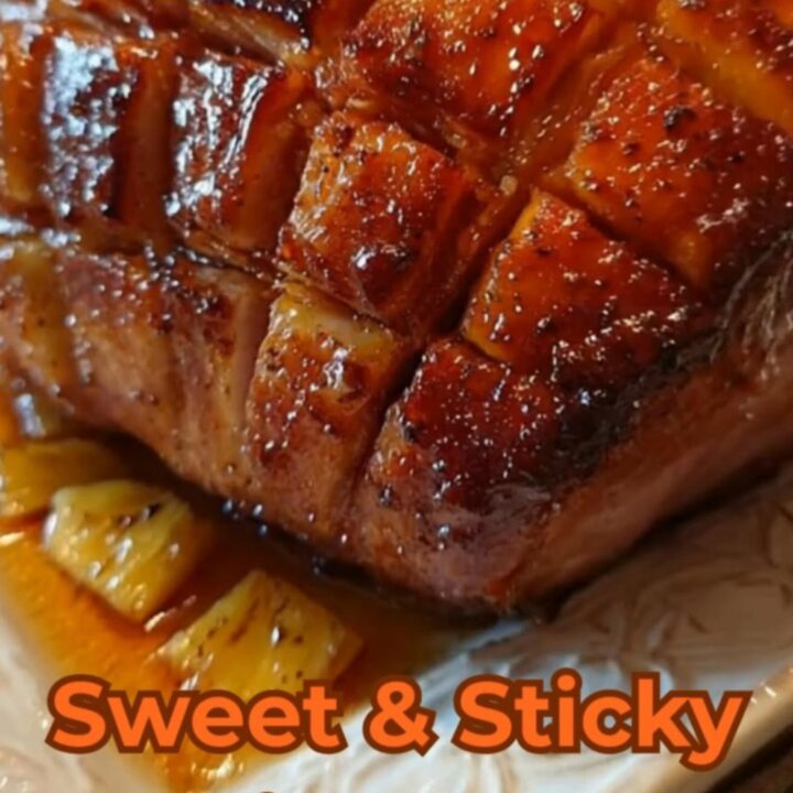 A beautifully roasted holiday ham with a glossy, caramelized diamond crust on a white serving platter