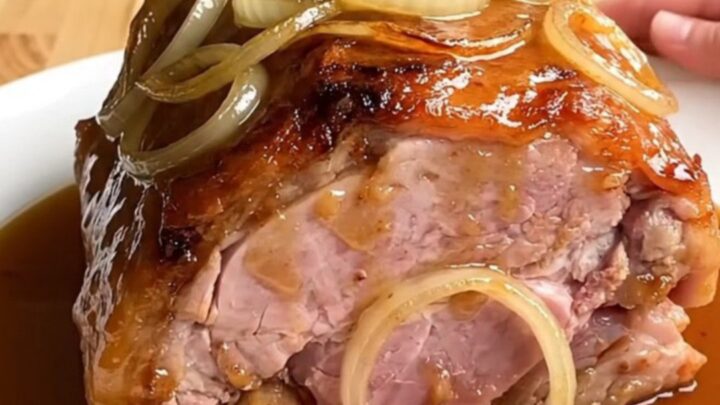 A whole boneless ham braised in a slow cooker with onions and a maple beer glaze.