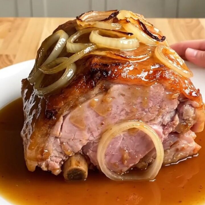 A whole boneless ham braised in a slow cooker with onions and a maple beer glaze.
