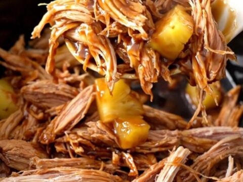 A bowl of shredded teriyaki pork with pineapple chunks and a glossy sauce.