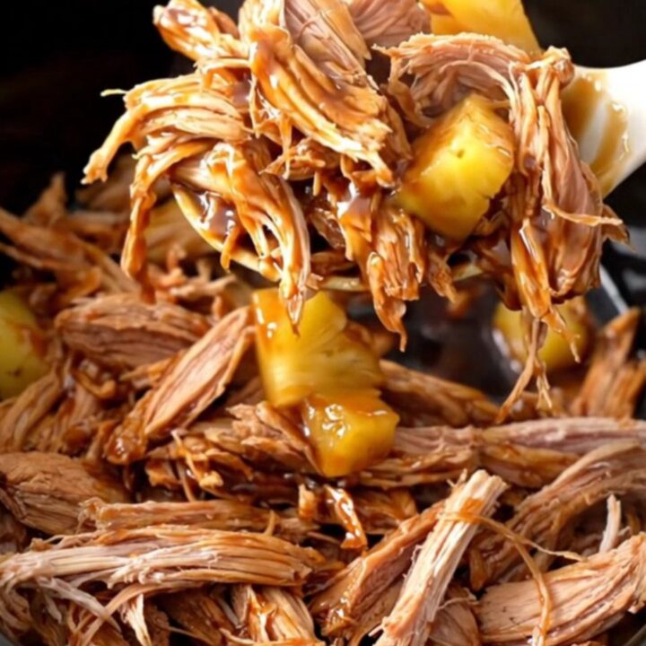A bowl of shredded teriyaki pork with pineapple chunks and a glossy sauce.