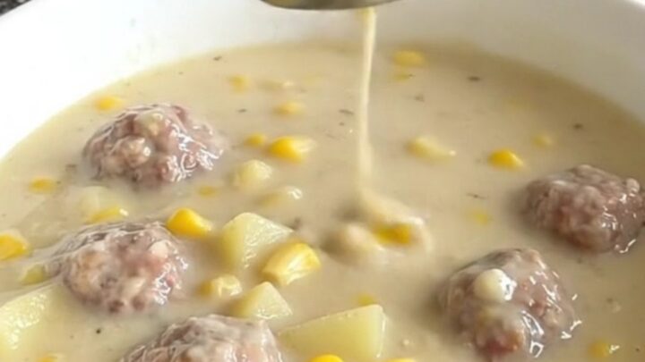 A close-up of a creamy turkey meatball and corn chowder in a white bowl.