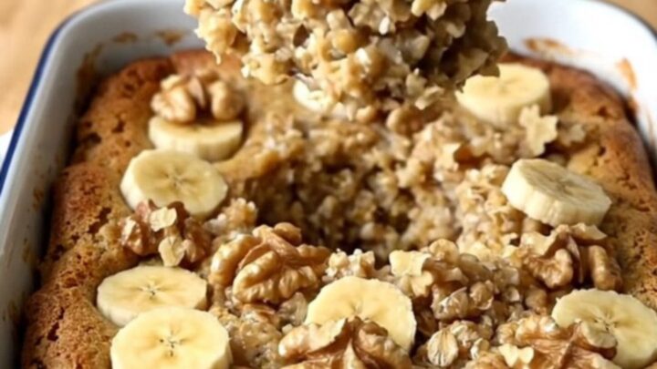 A top-down view of a rectangular baker filled with banana bread baked oatmeal on a wooden countertop.
