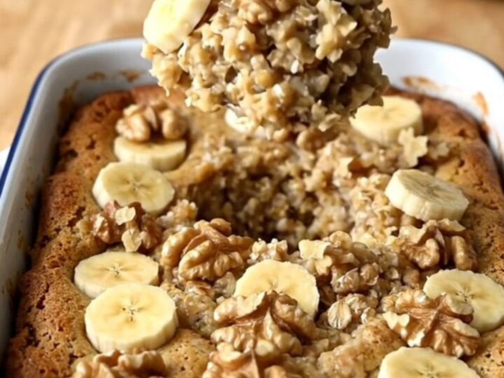 A top-down view of a rectangular baker filled with banana bread baked oatmeal on a wooden countertop.