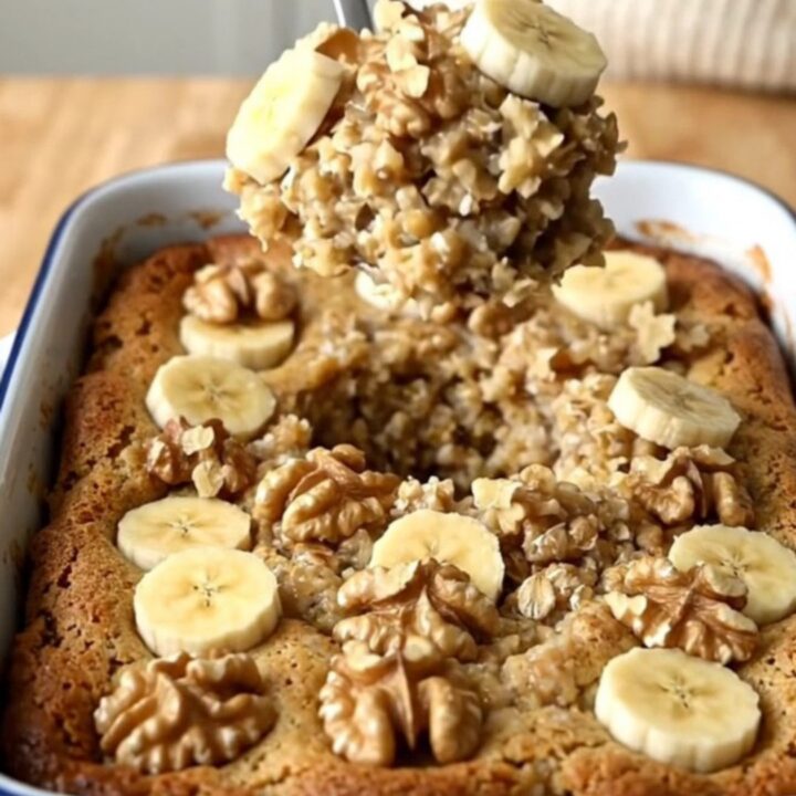 A top-down view of a rectangular baker filled with banana bread baked oatmeal on a wooden countertop.