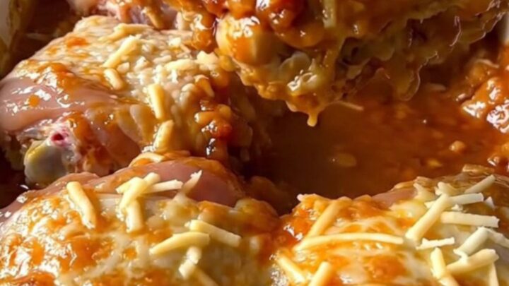 A top-down view of a rectangular baking dish filled with golden baked chicken thighs and rice.