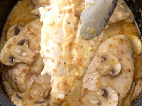 A close-up of tender chicken breasts served in a creamy mushroom sauce, garnished with a sprinkle of paprika.