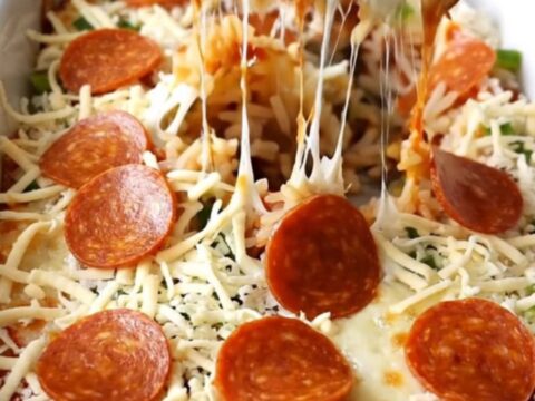 A top-down view of a rectangular baking dish filled with a pepperoni pizza stuffed pepper casserole.