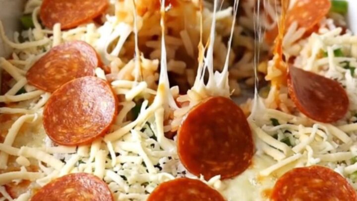 A top-down view of a rectangular baking dish filled with a pepperoni pizza stuffed pepper casserole.